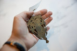 Vintage African bronze owl medallion held in hand to demonstrate scale and handmade texture.