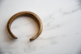 Finely incised snake scale pattern on the antique bronze cuff's warm patina.