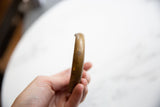Side view of the antique bronze cuff showing its smooth, age-worn patina.