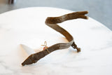 Side view of the antique bronze snake cuff showing its sculptural serpentine shape and aged patina.