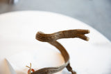 Detailed craftsmanship of incised patterns on the forked tip of the bronze snake arm cuff.