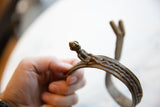 Detailed cast bronze rider figure with aged patina on an antique snake arm cuff.