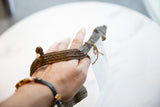 Antique bronze snake arm cuff held in hand to show its scale and hand-worked texture.