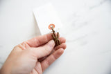 Small vintage African bronze pendant held in hand to show scale and texture.