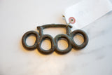 Handmade African bronze knuckles showing a rich, weathered patina and rustic texture.