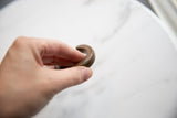 Close-up showing the tactile quality and etched details of the antique bronze cuff.