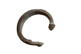 Antique African bronze snake cuff bracelet with an etched scale texture and dark, aged patina.