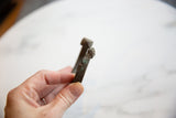 Detail of the antique bronze cuff showing the chipped end, incised texture, and green patina.