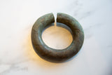 Full view of the antique African currency bracelet showing its aged patina and circular form.