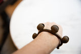 Lobi bell cuff bracelet on an arm, showcasing its spiraled details and copper alloy patina.
