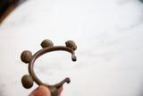 Coiled bell details and rich patina on a vintage African Lobi copper bracelet.