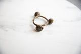 Angled view of a vintage Lobi bronze cuff bracelet highlighting its three-bell design.