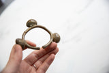 Vintage Lobi bell cuff bracelet in hand, displaying its unique bronze shape.