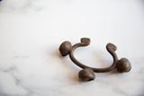 The sculptural form of a vintage Lobi bell cuff bracelet in dark bronze alloy.