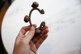Vintage African bronze Lobi bell cuff held in hand showing its scale and shape.