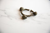 The twisted bronze band and round bell terminals of a vintage African Lobi cuff.