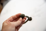 A detailed view of the ribbed texture and patina on the bronze Lobi bell cuff.