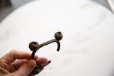 The textured patina on the bell end of the vintage African bronze Lobi cuff.