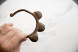 Side profile of a vintage African bell cuff with textured bell details.