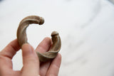 Close-up of the handcrafted terminal and aged patina on a twisted African cuff.