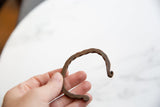 The rugged, hand-worked texture and open C-shape of an antique African copper cuff.