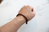 The handmade antique twisted copper cuff shown on a wrist for scale.