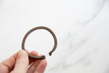 Antique copper snake cuff showing its aged patina and open, coiled-end design.