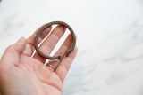 Antique copper bracelet cuff held to show its handmade texture and coiled terminals.