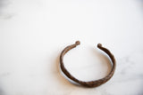 Detail of the hand-forged twisted iron design on the vintage African bracelet with patina.