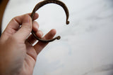 Detail of the double banded twisted design and curled end of the antique African iron bracelet.