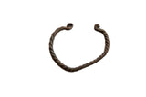 Antique African copper alloy bracelet with a twisted design and a rich, dark patina.