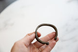 The open shape and aged bronze texture of an antique African cuff bracelet.