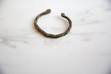 Collectible antique African cuff with a twisted, handcrafted texture and deep copper patina.