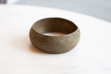 Textured floral design and aged patina on an antique African bronze bracelet.