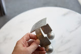 Antique aluminum cuff held to show its substantial size and hand-etched geometric details.
