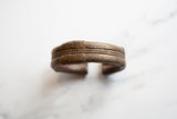 Hand-etched patterns and central rope texture on the antique African bronze cuff.