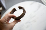 Antique African bronze cuff bracelet held to demonstrate its substantial size and form.