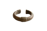 Antique African oxidized bronze cuff bracelet with a textured geometric design.