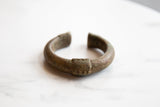 Geometric markings and textured patina on a collectible antique African bronze cuff.