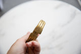 Aged golden patina and etched stripes on the open ends of a collectible African bronze cuff.