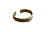 Antique African bronze cuff bracelet with an oxidized patina and incised stripe design.