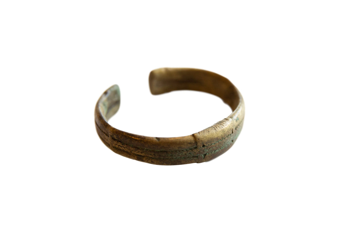 Antique African bronze cuff bracelet with an oxidized patina and incised stripe design.