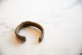 The thick, open form of a collectible antique African bronze bracelet.