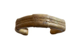 Antique African bronze cuff bracelet with a textured striped design and aged golden patina.