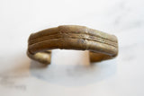 Hand-worked striped detailing and rich golden patina on the antique bronze bracelet.