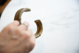 In-hand view of the antique African bronze cuff, showing its substantial form and aged patina.