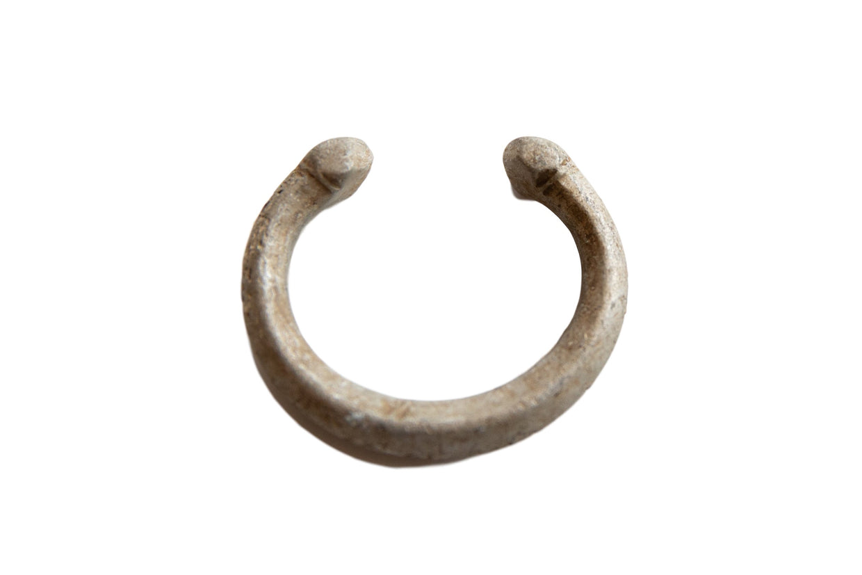 Antique African aluminum snake cuff bracelet with a weathered, textured patina.