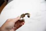 Antique African twisted aluminum cuff bracelet held in hand to show scale and texture.