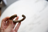 Side view of an antique bronze bracelet showing its rustic texture and open design.