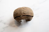 Side profile of a handmade antique African copper cuff showing its striped texture and aged patina.